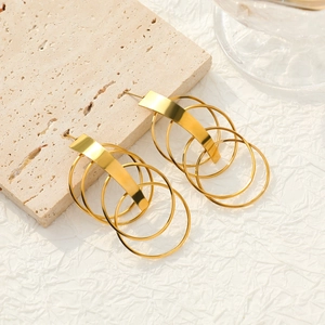 Elegant gold multi-layered circular tassel earrings on a natural stone background
