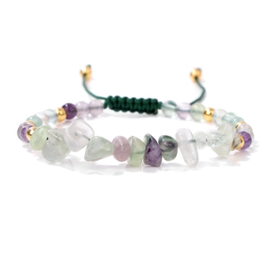 Detailed view of woven stone bracelet with green and purple natural chips and gold beads