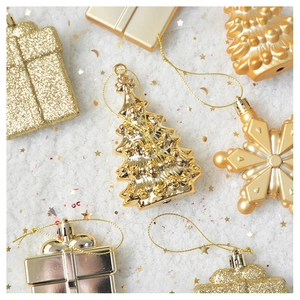 Close-up of gold Christmas tree and snowflake ornaments with shiny glitter finish
