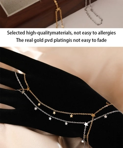 Macro detail of star pendant hand chain with gold PVD plating on a black display model