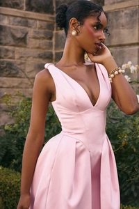 Détail d'une robe en satin rose clair avec décolleté en V profond et design sans manches