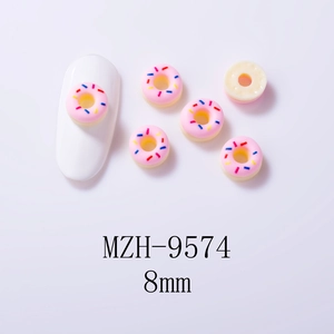 Close-up of pink 8mm resin donut nail charms with colorful sprinkles on white nails