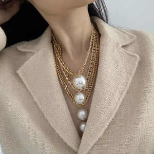 Elegant multi-layer gold chain necklace featuring four graduated white pearl pendants