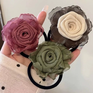 Three oversized organza rose hair scrunchies in pink, beige, and olive green colors