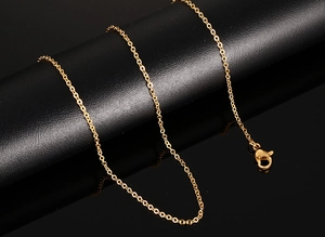 Detail shot of the golden O-chain necklace with a secure lobster clasp on a dark display