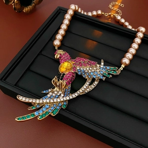 Detail of a parrot pendant with colorful rhinestones and yellow gemstone on pearl chain
