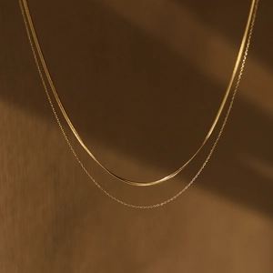 Detail der 18K vergoldeten zweilagigen Schlangen- und O-Gliederkette bei warmer Beleuchtung