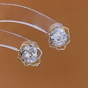 Detailed macro view of hollow rose stud earrings with champagne gold base and cubic zirconia