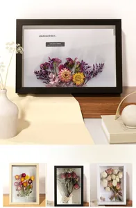 Detail showing 3D hollow wooden picture frames with dried flowers in black, wood, and white