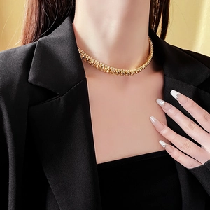 Close-up of a French style gold pendant necklace with crystals worn by a model