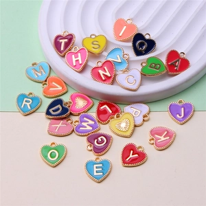 Macro shot of colorful heart-shaped alloy pendants with gold letters on a ceramic tray