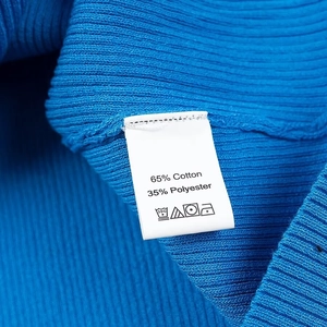 Detail der blauen Rippstrick-Stoffstruktur mit dem 65% Baumwolle Pflegeetikett