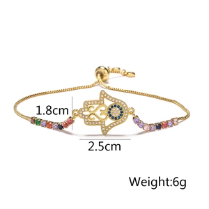 Detail view of gold 18K Hamsa Hand bracelet with colorful zircons and Evil Eye