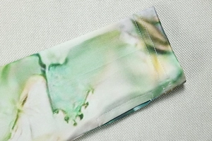 Detailed close-up showing the precise double-needle stitching on green floral hem fabric