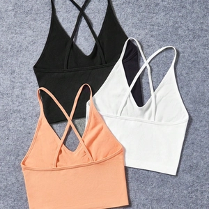 Trois brassières de sport côtelées en noir, blanc et rose avec fines brides croisées