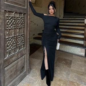 Detail of off-shoulder black maxi dress with elegant side ruching and a high slit design