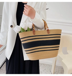 Detail of hand-woven tote bag with classic black stripes and unique bamboo handle