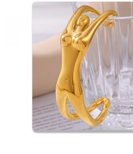 Künstlerisches Armband in Gold mit weiblicher Silhouette an einem Glasrand hängend