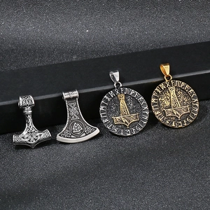 Dettaglio macro dei ciondoli Viking Mjolnir con rune nordiche su sfondo nero testurizzato