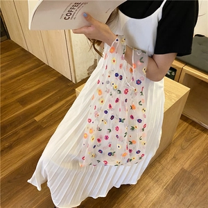 Detailed embroidery of colorful flowers on a white sheer mesh tote bag for summer