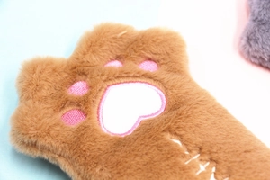 Close-up of brown plush cat paw pencil case with pink embroidered heart paw pads