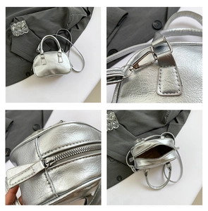 Detail of silver pleated leather mini bag with polished metal zipper and hooks