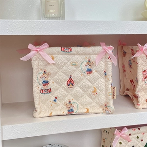 Close-up of quilted fabric storage basket with circus prints and pink ribbon detail