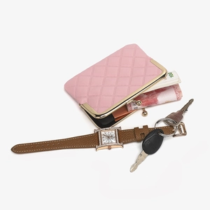 Pink quilted clasp purse and H-shaped diamond watch set with key ring on white background
