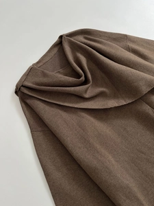 Detail des eleganten Schalkragens und der feinen Strickstruktur dieser braunen Strickjacke