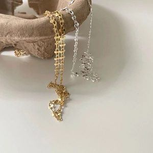 Minimalist s925 silver link chain necklace in gold and silver tones on a textured vessel