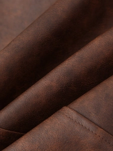 Gros plan sur le similicuir marron foncé texturé avec détails de couture précis
