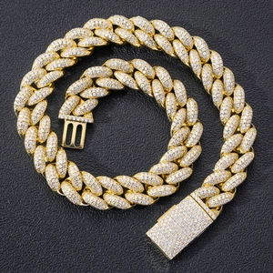 Close-up of 20mm gold Cuban chain with micro-paved cubic zirconia stones on textured background