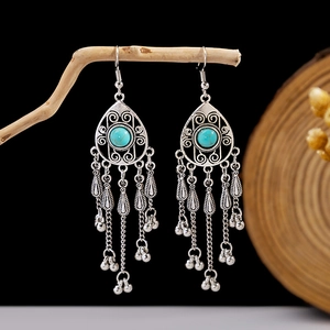 Detail of silver bohemian earrings with blue turquoise and metal tassel fringe charms