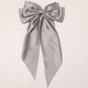 Close-up of elegant silver grey satin bow hair clip with smooth silk texture and soft sheen