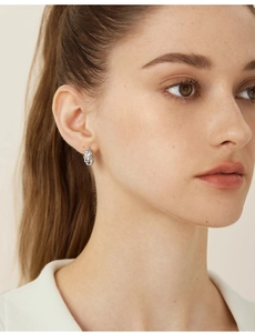 Close-up of a silver twisted spiral hoop earring worn by a model for a stylish look