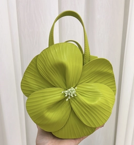 Detail of the green 3D floral petal tote bag showing the textured leather and center stamen