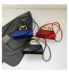 Three crocodile pattern handbags in blue, red, and black with sculpted gold handles