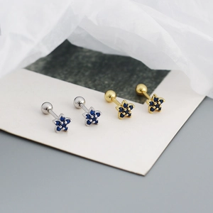 Macro shot of flower stud earrings with blue zircon in silver and gold plating
