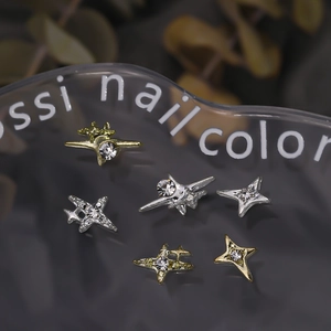 Macro shot of 3D star-shaped nail charms with rhinestones in gold and silver finish