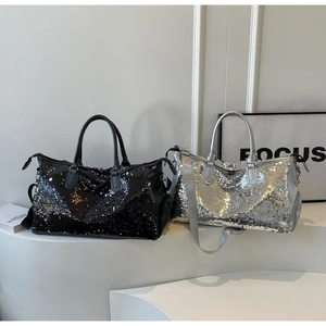 Primer plano de bolsas de viaje con lentejuelas negras y plateadas y textura brillante