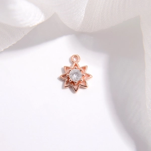 Close-up of rose gold star pendant with clear zircon inlay on white fabric background