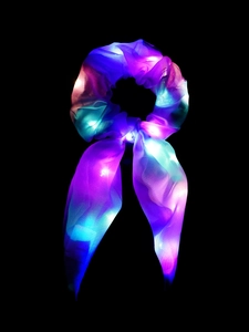 Detail of LED light-up hair scrunchie with bow made of colorful glowing organza fabric