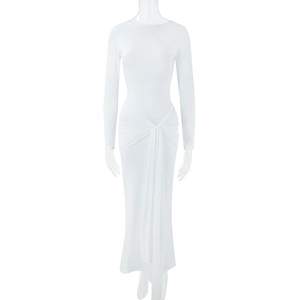 Detail of waist twist knot and elegant draping on a white long sleeve slim fit dress