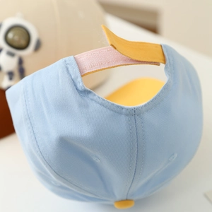 Detail view of the yellow Velcro strap and stitching on the light blue kids baseball cap