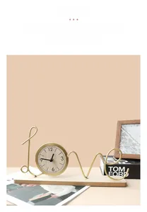 Close-up of modern gold metal Love clock with wooden base on a minimalist desk