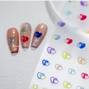 Detailed view of colorful 3D nested heart nail art stickers on clear nail tips