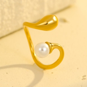 Elegant geometric gold stainless steel open ring with pearl detail on stone background