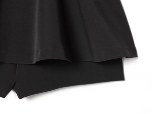 Détail de l'ourlet à volants superposés et des coutures de ce combishort noir chic