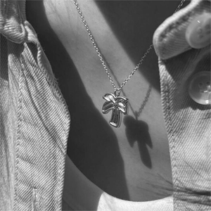 Detailed view of a minimalist 925 sterling silver palm tree pendant on a thin chain