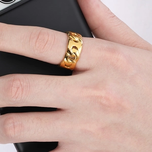 Macro detail of 18k gold plated Cuban chain ring on finger holding a smartphone